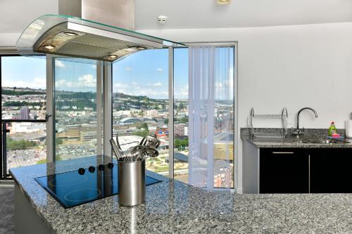 a kitchen with a view of a city at Just Stay Wales - Meridian Tower Marina & City View - 2 Bed Apartment in Swansea