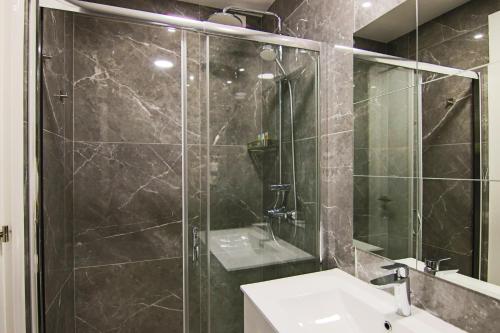 een badkamer met een glazen douche en een wastafel bij Phaedrus Living: Luxury Suite Nicosia 508 in Nicosia