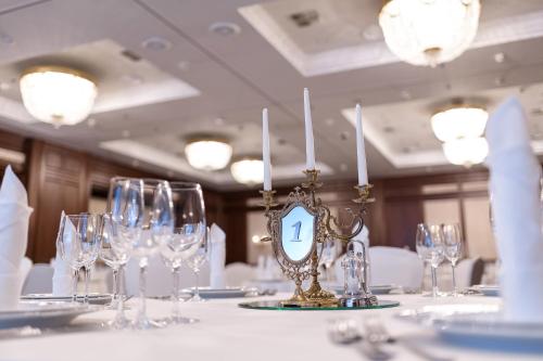 a table with wine glasses and a clock on it at Premier Palace Hotel Kyiv in Kyiv