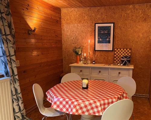 een eetkamer met een tafel en witte stoelen bij Knus boshuisje middenin de natuur in Doldersum