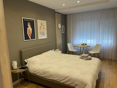 a bedroom with a bed and a table and chairs at PRONTO apartman & PRONTO studios in Kruševac