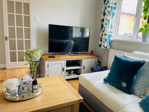 sala de estar con sofá y TV de pantalla plana en Tanglewood house Abergavenny with private parking, en Abergavenny