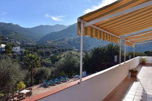 a balcony with chairs and a view of mountains at Siempre Verde in Alcaucín