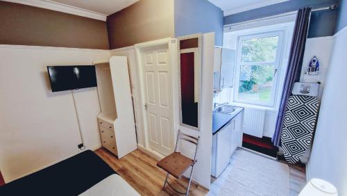 a small room with a door and a sink at Bemersyde Guest House in Mansewood