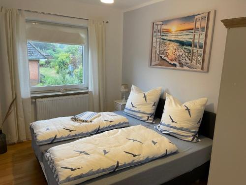 two beds in a small room with a window at Family House in Kappeln