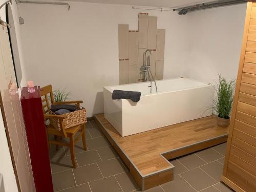 ein Badezimmer mit einer Badewanne, einem Tisch und einem Stuhl in der Unterkunft Family House in Kappeln