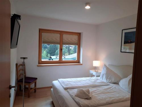 a white bedroom with a bed and a window at Apartment Bella Vista in Bad Kleinkirchheim