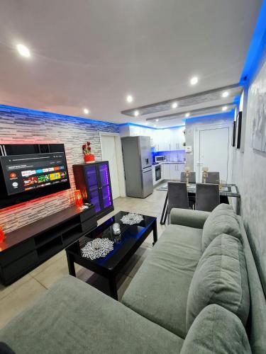 a living room with a couch and a flat screen tv at Hidden Lights Deluxe Apartment in Ayia Napa