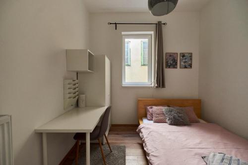 a bedroom with a desk and a bed and a window at Dembi at the Great City Park in Budapest