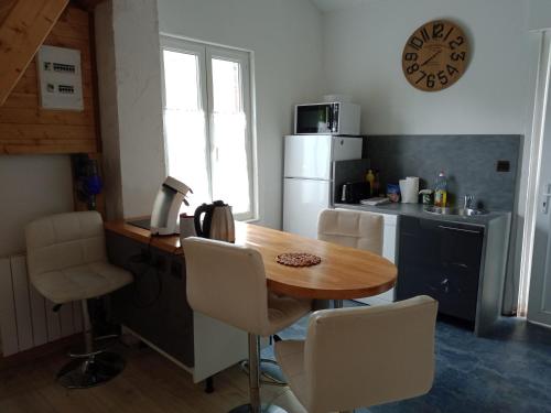 een keuken met een houten tafel en een witte koelkast bij Chalet du Sanglier in Rancennes