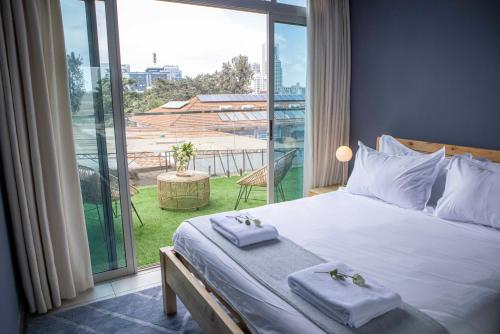 a bedroom with a large bed with towels on it at The Skies by YourHost, Westlands Nairobi in Nairobi