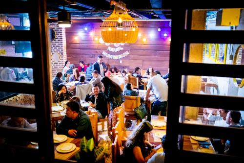 un grupo de personas sentadas en mesas en un restaurante en La Floresta de Cite Hotel, en Cite