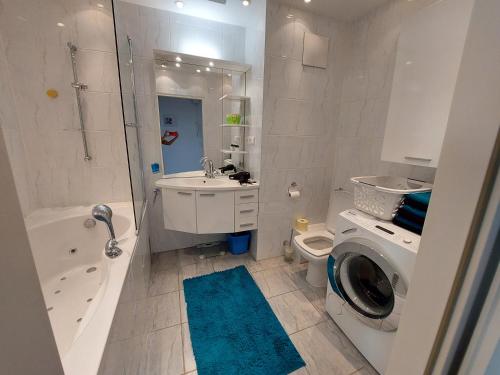 uma casa de banho com um lavatório e uma máquina de lavar roupa em Tower Apartment with private terrace next to UNO em Viena