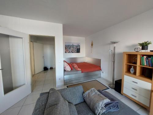 uma sala de estar com um sofá e uma cama em Tower Apartment with private terrace next to UNO em Viena
