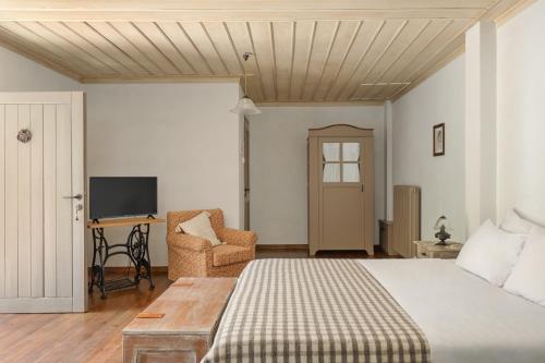 a bedroom with a bed and a desk and a television at Avragonio in Papigko