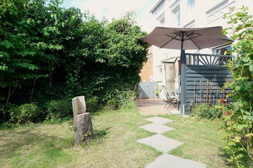 a patio with an umbrella next to a house at Ferienwohnung Seestern in zentraler Lage von Eckernförde in Eckernförde