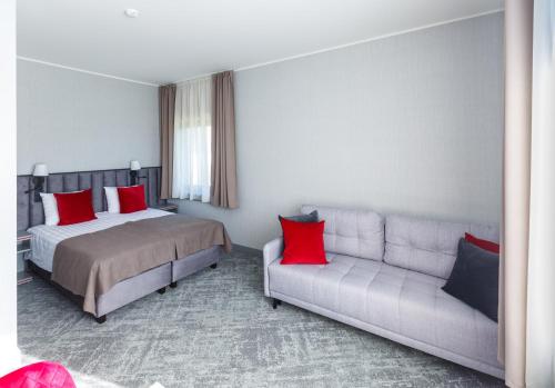 une chambre d'hôtel avec un lit et un canapé dans l'établissement Tõrva Veemõnula Spaahotell, à Tõrva