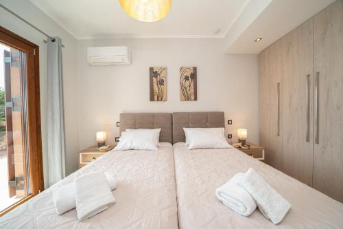 a bedroom with a large bed with two white pillows at Villa Cleopatra Fiskardo in Fiskardho