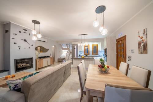 a dining room and living room with a table and a couch at Villa Cleopatra Fiskardo in Fiskardho