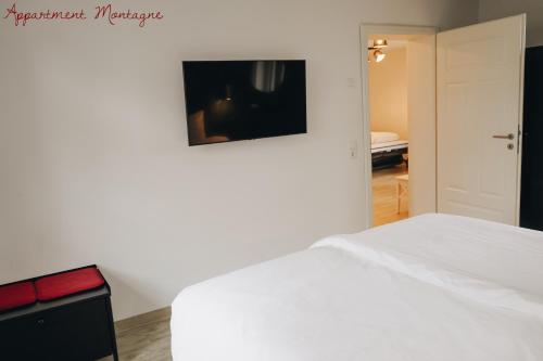 Un dormitorio con una cama blanca y una pintura en la pared en Apartements Zum Roten Lamm, en Bad Krozingen