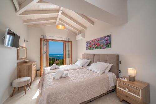 a bedroom with a bed and a view of the ocean at Villa Cleopatra Fiskardo in Fiskardho