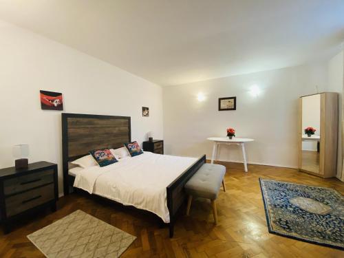 een slaapkamer met een groot bed en een tafel bij Apartment Werkstatt Castelului in Braşov