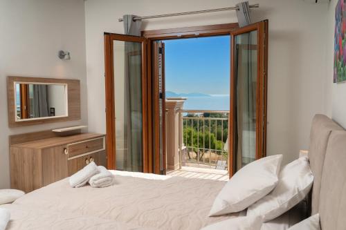 a bedroom with a bed and a large sliding glass door at Villa Cleopatra Fiskardo in Fiskardho