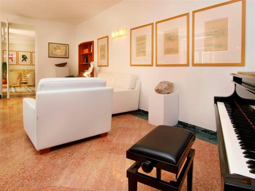 a living room with a white couch and a piano at Bellevue San Lorenzo (Adults Only) in Malcesine