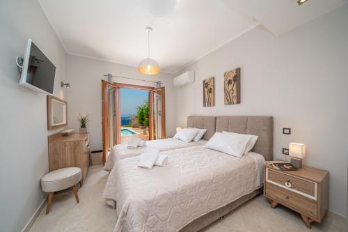 a bedroom with a large bed and a television at Villa Cleopatra Fiskardo in Fiskardho