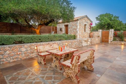 a wooden table and benches on a patio at Villa Cleopatra Fiskardo in Fiskardho