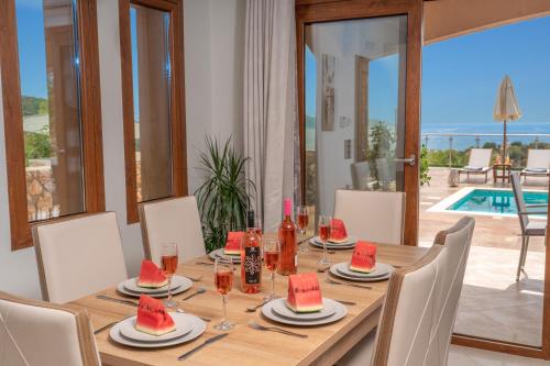 a dining room with a table with watermelons on it at Villa Cleopatra Fiskardo in Fiskardho