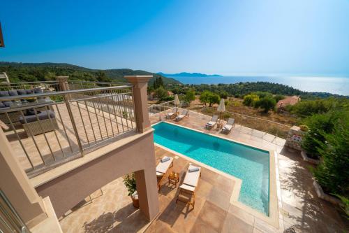 a balcony with a pool and a view of the ocean at Villa Cleopatra Fiskardo in Fiskardho
