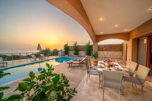 a patio with a table and chairs next to a swimming pool at Villa Cleopatra Fiskardo in Fiskardho