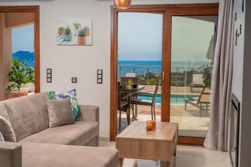 a living room with a couch and a view of the ocean at Villa Cleopatra Fiskardo in Fiskardho