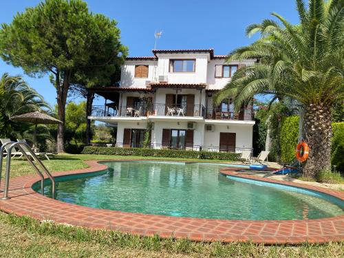 a house with a swimming pool in front of a house at Villa Xanthippi in Agia Paraskevi