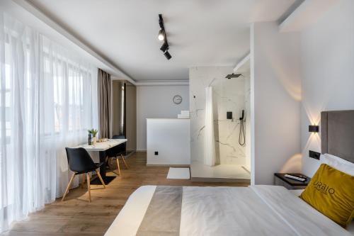 a bedroom with a bed and a desk in a room at Urbio Private Suites in Cluj-Napoca