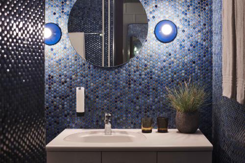 ein Bad mit einem Waschbecken und einem Spiegel in der Unterkunft Hotel Bad Murtensee in Murten
