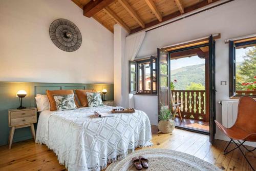 a bedroom with a bed and a balcony at Casa Rural Soleada para una Escapada Tranquila in Ceceda de Abajo