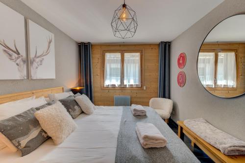 une chambre avec un grand lit et un miroir dans l'établissement Apartment Aiguille de Chamonix- Alpes Travel - Central Chamonix (sleeps 4), à Chamonix-Mont-Blanc