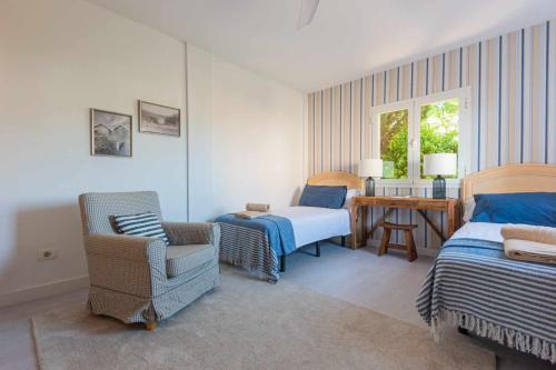 サンタクルス・デ・テネリフェにあるLuxury Villa y Ocean Viewのベッドルーム1室(ベッド2台、椅子、テーブル付)