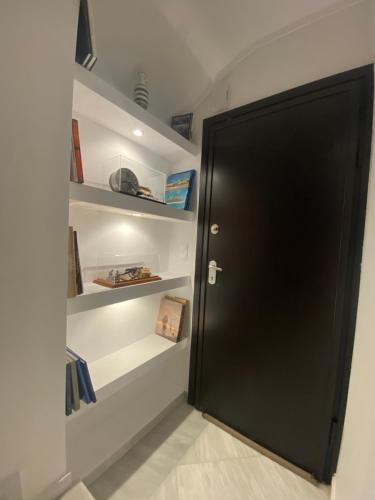 a black door in a room with shelves at Efi’s Apartment Nea Michaniona in Nea Michaniona