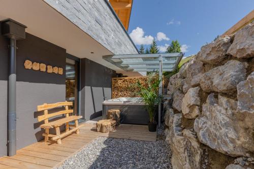 dom z drewnianym tarasem z wanną i kamienną ścianą w obiekcie ALM CHALET w mieście Annaberg im Lammertal