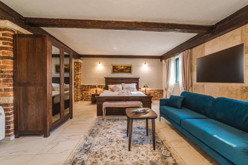 salon z niebieską kanapą i łóżkiem w obiekcie Casa Ra w mieście Podgorica