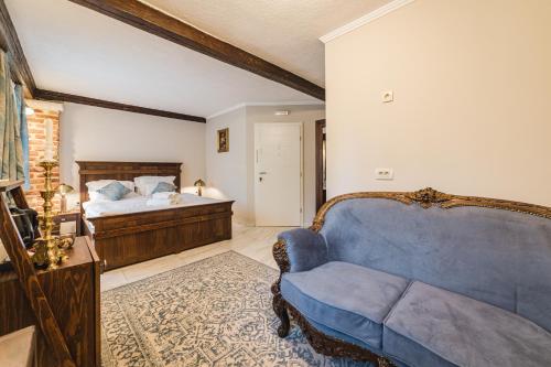- un salon avec un canapé bleu et un lit dans l'établissement Casa Ra, à Podgorica