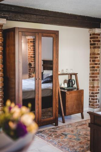 a bedroom with a bed and a wooden cabinet with a mirror at Casa Ra in Podgorica
