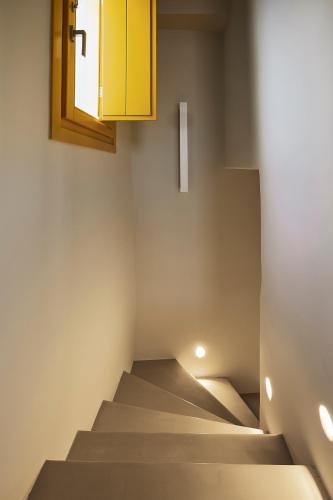 a staircase in a room with a yellow cabinet at Elaia Luxury Suites Mykonos in Mýkonos City