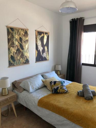 sypialnia z łóżkiem i 2 zdjęciami na ścianie w obiekcie L' Azotea del Sol appartement typique w mieście La Puebla
