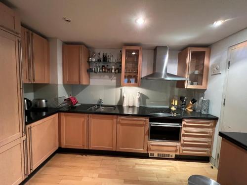 a kitchen with wooden cabinets and a stove top oven at Central London 1 bed Apartment in London