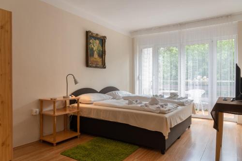 um quarto com uma cama, uma secretária e uma janela em Sylvia Ház em Tihany