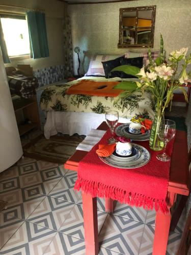 una habitación con una mesa con una cama y una mesa con flores en Suíte Cravo & Canela, en São Pedro da Serra